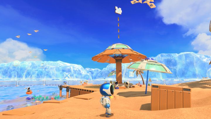 Near the shore there is a large umbrella with some coins and the 3rd puzzle piece floating above it - Astros Playroom: Bot Beach - walkthrough - Cooling sources - Astros Playroom Guide