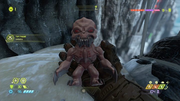 Now it is enough to jump off the ledge of the rock on the big stone head of the demon, and the doll will fall into your hands - Doom Eternal: Cultist Base secrets maps and location - Collectibles and secrets - Doom Eternal Guide