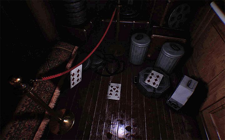 Schauen Sie sich in der Gegend um und finden Sie die drei Spielkarten, die auf dem Boden liegen – wie im Bild oben gezeigt – Das dritte Puzzle mit einem Vorhängeschloss |  Layers of Fear 2-Rätsellösungen – Akt 4 – Atmen – Layers of Fear 2-Leitfaden